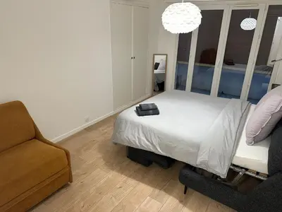 a bedroom with a bed and a couch and a chair at 2 Bedroom Ocean view Apartment in Nice