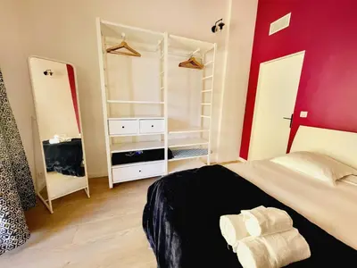 a bedroom with a black bed and a red wall at Enjoy old town side Nice-Modern apt-loft with AC in Nice