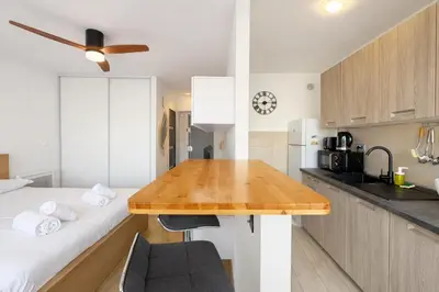 a kitchen with a wooden table in a room at Smolett 2 Pers Terrazza WiFi in Nice