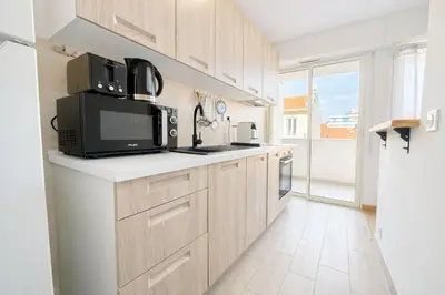 a kitchen with wooden cabinets and black appliances at Smolett 2 Pers Terrazza WiFi in Nice