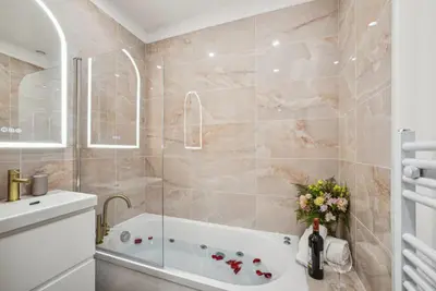 a bathroom with a bath tub and a sink at Lavie Maison Hot Tub and AC in Nice