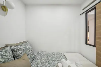 a bedroom with a bed with pillows and a window at Lavie Maison Hot Tub and AC in Nice