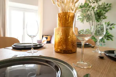 a table with wine glasses and a vase on it at Old Town Diamond, adorable sunny apartment with AC in Nice
