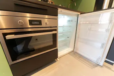 a kitchen with an empty refrigerator and an open oven at Old Town Diamond, adorable sunny apartment with AC in Nice