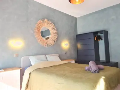 a bedroom with a large bed and a mirror at Charmant appartement - Climatisation - Nice in Nice