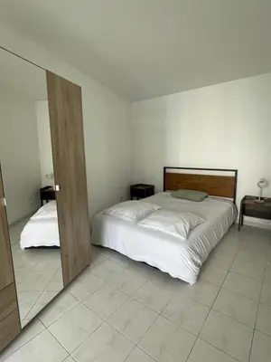 a bedroom with a large white bed and two tables at Le soleil Niçois, proche du port in Nice