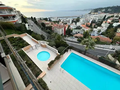 arial view of a swimming pool on a building with a city at L'évidence in Nice