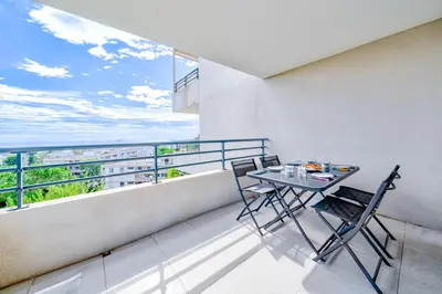 a balcony with a table and chairs and the ocean at Magnifique 4 pers,Clim,parking in Nice
