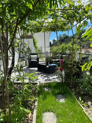 a patio with a couch and some plants at Studio climatisé avec terrasse ombragée dans maison au calme et dans la verdure in Nice