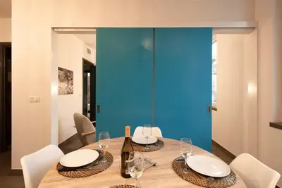 a dining room with a table with chairs and a blue wall at 