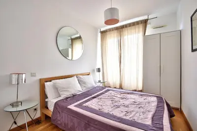 a bedroom with a large bed and a mirror at 2P balcon Vue Mer YourHostHelper 2 mins de la mer in Nice