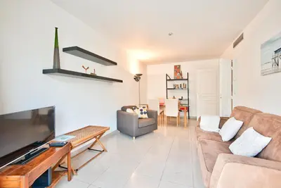 a living room with a couch and a table at 2P balcon Vue Mer YourHostHelper 2 mins de la mer in Nice