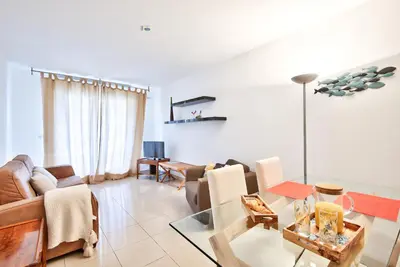 a living room with a couch and a table at 2P balcon Vue Mer YourHostHelper 2 mins de la mer in Nice