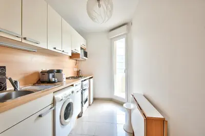 a kitchen with a sink and a washing machine at 2P balcon Vue Mer YourHostHelper 2 mins de la mer in Nice