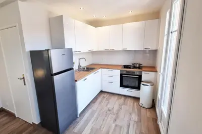 a kitchen with white cabinets and a refrigerator at 