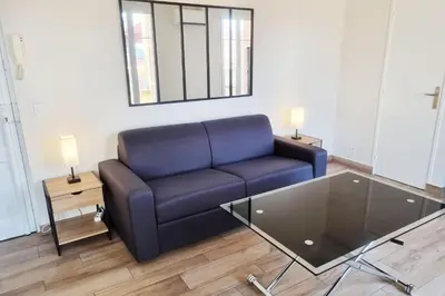 a living room with a blue couch and a glass table at 