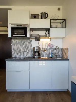 a kitchen with white cabinets and a sink at Heliotel Marine Studio avec balcon au 4eme étage à 200m de la mer in Saint-Laurent-du-Var