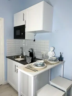 a kitchen with white cabinets and a counter top at blue sun in Nice