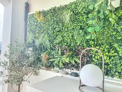 a white chair sitting next to a green wall at Riviera-King-Studio in Villefranche-sur-Mer