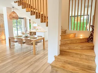 a dining room and kitchen with a wooden floor and stairs at Villa moderne pour 8 personnes - Vue sur Nice ! in Nice