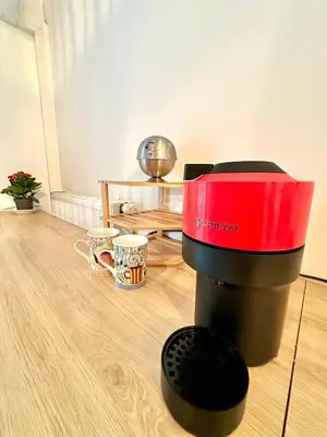 a red and black coffee maker sitting on a wooden floor at Studio 600 m de la Promenade des Anglais in Nice