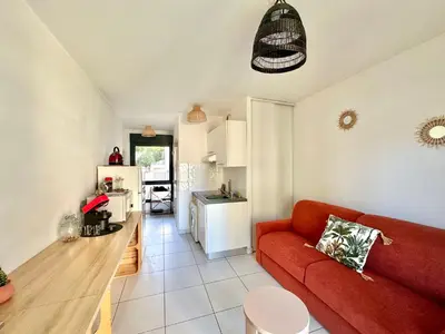 a living room with a red couch and a kitchen at Studio 600 m de la Promenade des Anglais in Nice
