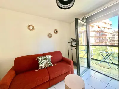 a living room with a red couch and a balcony at Studio 600 m de la Promenade des Anglais in Nice