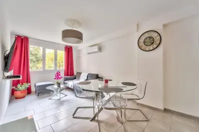 a living room with a table and chairs and a clock at Modern 2BR Flat - Haut de Nice in Nice