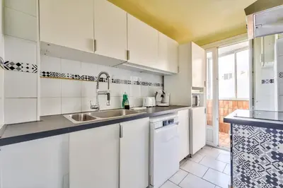 a kitchen with white cabinets and a sink at Modern 2BR Flat - Haut de Nice in Nice