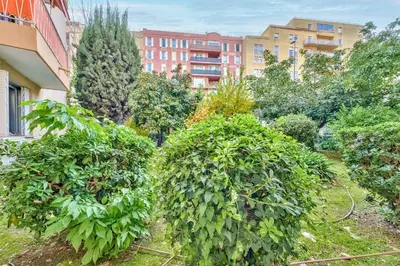 a garden with trees and buildings in the background at Modern 2BR Flat - Haut de Nice in Nice