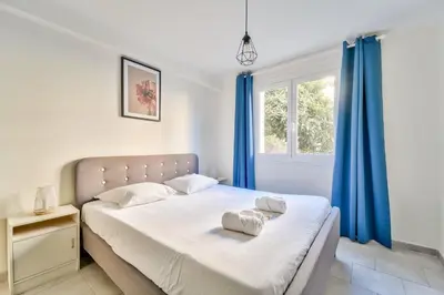 a bedroom with a large bed with blue curtains at Modern 2BR Flat - Haut de Nice in Nice