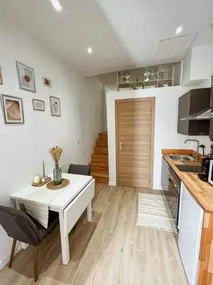 a kitchen and living room with a table and a counter at Studio cosy Nice in Nice