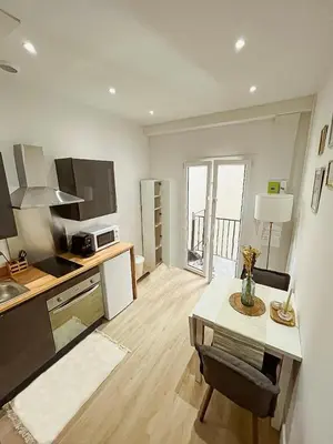 a living room with a kitchen and a table with a table at Studio cosy Nice in Nice