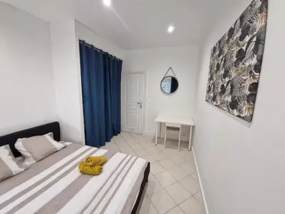 a living room with a couch and a kitchen at Appartement 4 pièces - gare Nice riquier in Nice