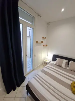a bedroom with a bed with a red curtain at Appartement 4 pièces - gare Nice riquier in Nice