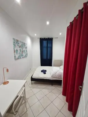 a kitchen with a couch and a tv on the wall at Appartement 4 pièces - gare Nice riquier in Nice