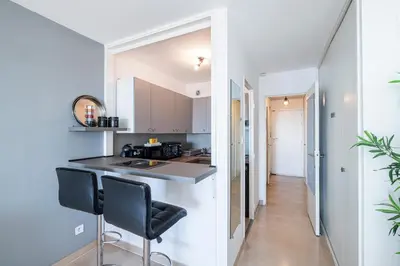 a kitchen with a counter and two chairs in a room at Sea View & Promenade des Anglais Studio in Nice