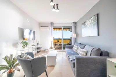 a living room with a blue couch and chairs at Sea View & Promenade des Anglais Studio in Nice