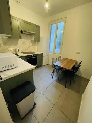 a kitchen with a table and chairs in a room at Appartement Californie Beach in Nice