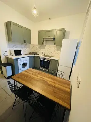 a kitchen with a wooden table and a refrigerator at Appartement Californie Beach in Nice