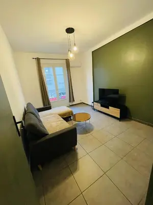 a living room with a couch and a flat screen tv at Appartement Californie Beach in Nice