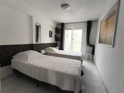 two beds in a room with a window at Nizza-Azur vue mer in Nice