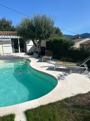 a swimming pool in a yard with a patio at L'olivier in Gattières