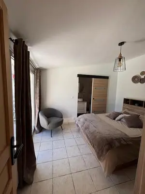 a bedroom with a bed and a chair in it at L'olivier in Gattières