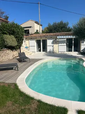 a swimming pool in front of a house at L'olivier in Gattières