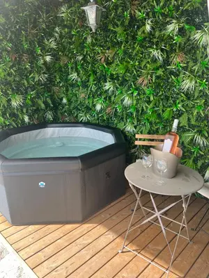a hot tub on a wooden deck next to a table at Villa loucisa Nice piscine vue mer 8 chambres 24 couchages in Nice