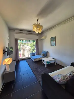 a living room with a couch and a table at Appartement à 2 pas de la Promenade des Anglais vue mer 7 avenue de Fabron in Nice
