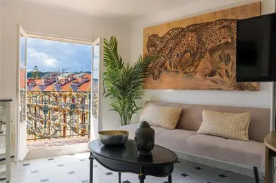 a living room with a couch and a large window at Perchoir au coeur de Nice in Nice