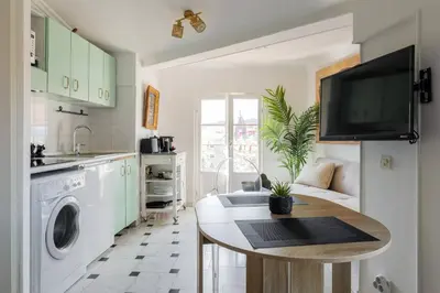 a kitchen with a table and a tv on the wall at Perchoir au coeur de Nice in Nice