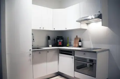 a white kitchen with white cabinets and a stove at Apartment Massena in Nice